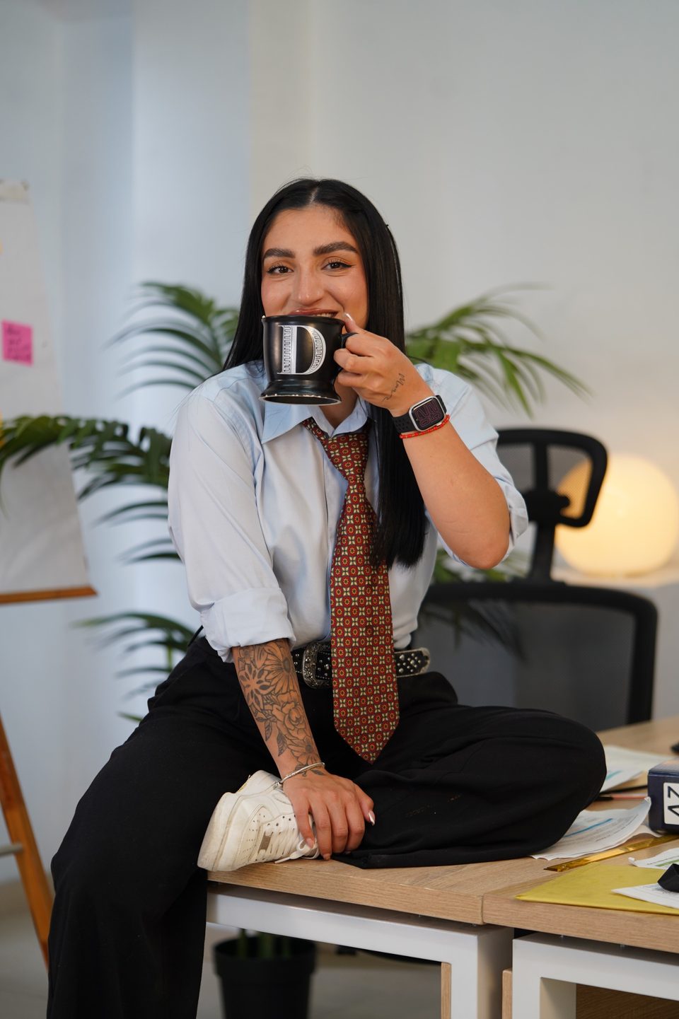 Camila Quiroga en una sesión editorial de oficina tomando café