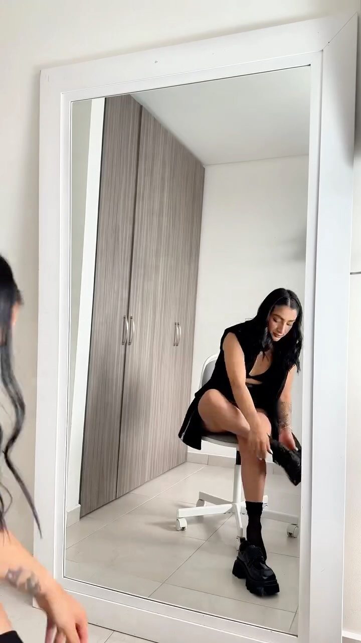 Camila Quiroga con un look negro frente al espejo en contenido de moda para Zohet